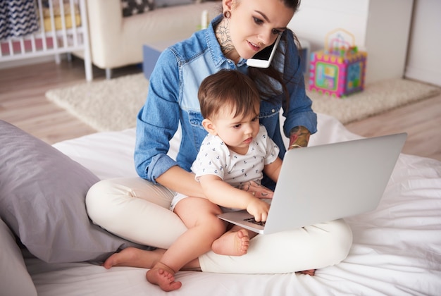 Jeune mère travaillant à domicile avec son fils