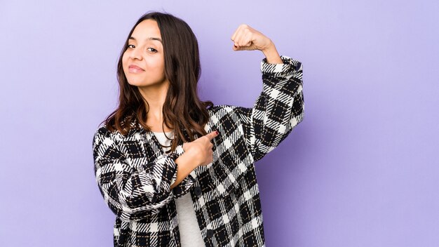 Jeune métisse femme hispanique montrant le geste de force avec les bras, symbole du pouvoir féminin