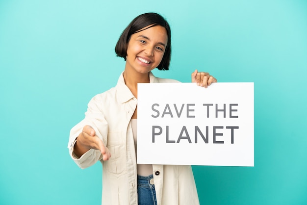 Jeune métisse femme isolée sur fond bleu tenant une pancarte avec texte Save the Planet faire un accord
