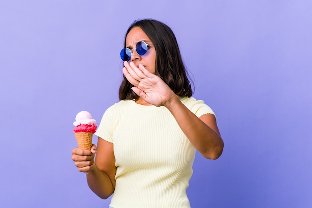 Jeune métisse femme mangeant une glace faisant un geste de déni