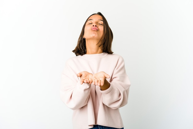 Jeune métisse femme pliant les lèvres et tenant les paumes pour envoyer un baiser d'air.