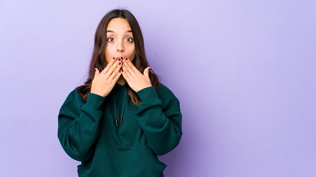 Jeune métisse hispanique femme isolée choquée couvrant la bouche avec les mains.