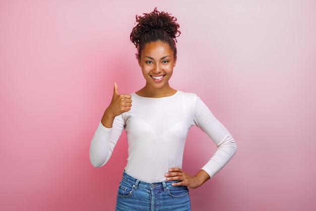 Jeune mulâtre heureuse femme debout avec les pouces