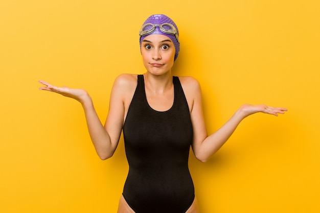 Jeune nageur caucasien femme doutant et haussant les épaules en remettant en question le geste.