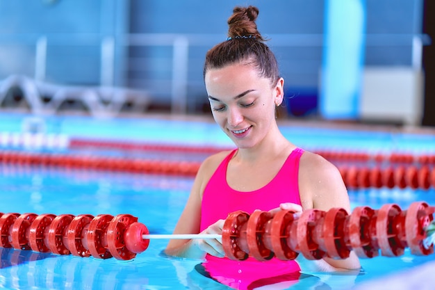 Jeune nageuse en maillot de bain pendant la détente dans la piscine dans le centre de loisirs