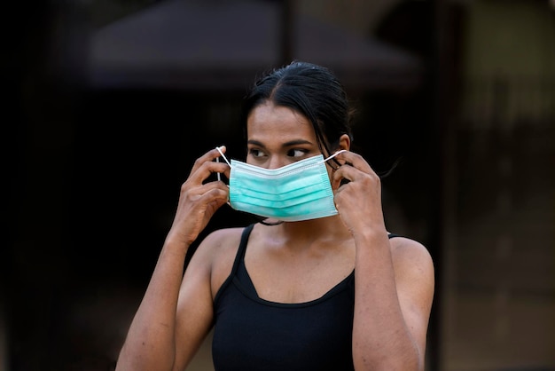 Un jeune noir à l'extérieur portant un masque de protection