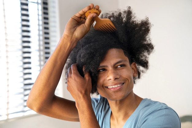 Jeune noir prenant soin des cheveux afro