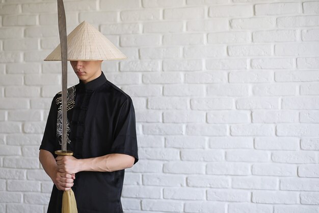 Jeune novice asiatique sur un fond de mur de briques blanches