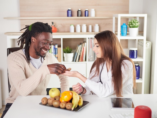 Une jeune nutritionniste au bureau suggère de manger du gingembre à sa patiente