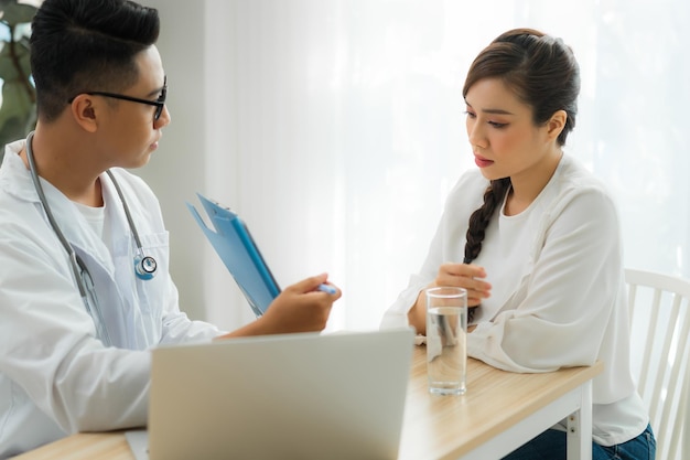 Jeune Obstétricien Gynécologue Masculin Consultant Un Patient En Clinique Ou à L'hôpital