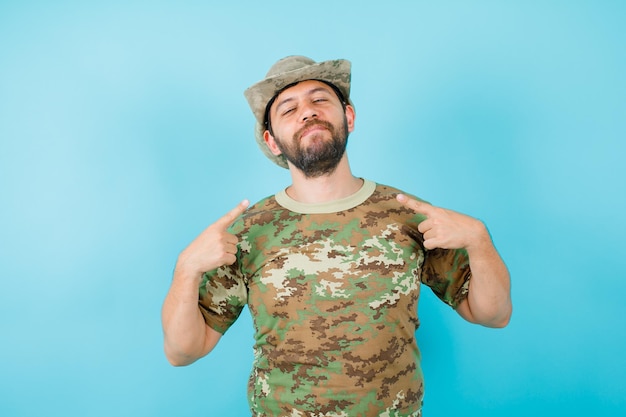 Le jeune officier ferme les yeux et se pointe avec les index sur fond bleu