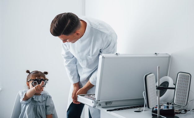 Le jeune ophtalmologiste est avec une petite visiteuse à la clinique.