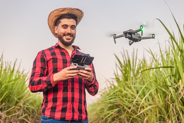 Jeune ouvrier agricole agronome utilisant un drone pour l'analyse des cultures informatisation automatisation de la plantation Drone à usage agricole