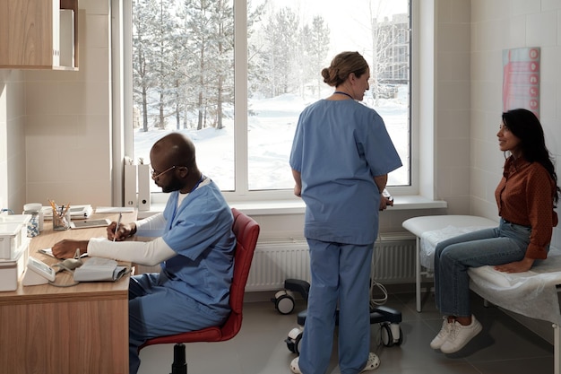 Jeune patiente attendant un examen médical et parlant à une infirmière