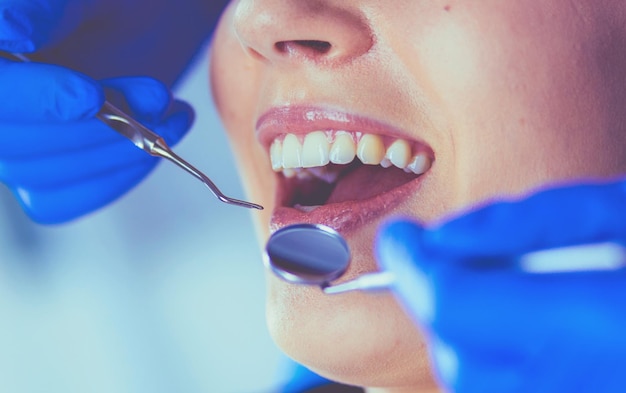 Jeune patiente avec la bouche ouverte examinant l'inspection dentaire au bureau du dentiste