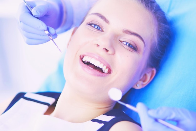 Jeune patiente à bouche ouverte examinant l'inspection dentaire au cabinet du dentiste