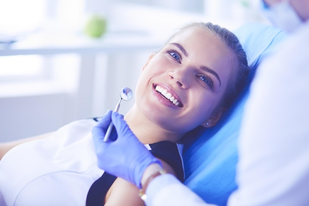 Jeune patiente avec un joli sourire examinant l'inspection dentaire au bureau du dentiste