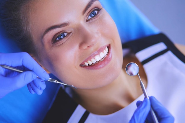 Jeune patiente avec un joli sourire examinant l'inspection dentaire au bureau du dentiste