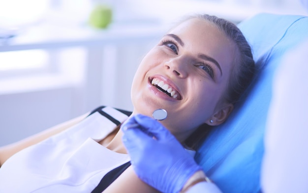 Jeune patiente avec un joli sourire examinant l'inspection dentaire au bureau du dentiste