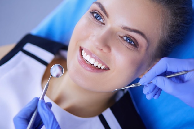 Jeune patiente avec un joli sourire examinant l'inspection dentaire au bureau du dentiste