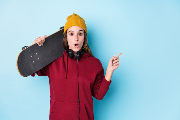 Jeune patineuse caucasienne isolée pointant vers le côté