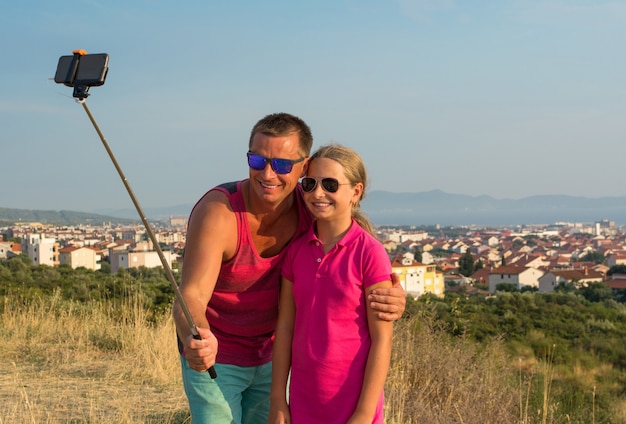 Jeune père avec fille prenant selfie à l'extérieur
