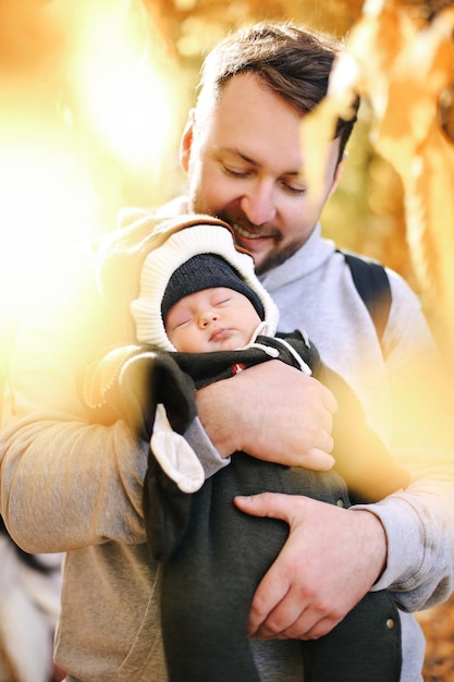 Jeune père et jeune enfant posant positivement dans la nature pendant la période chaude de la journée