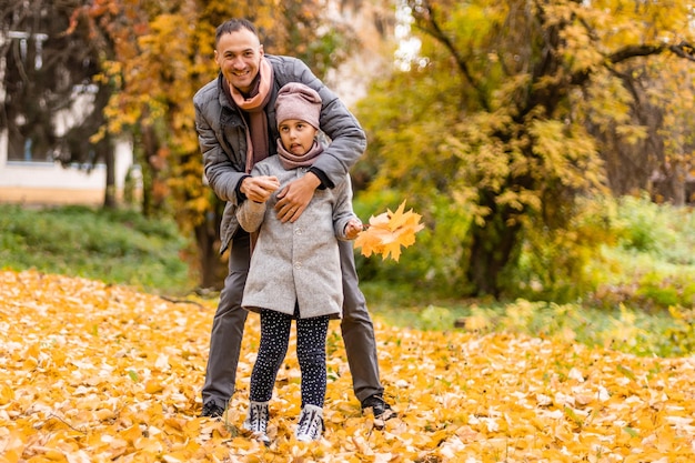 jeune père et petite fille marchant dans le parc d'automne