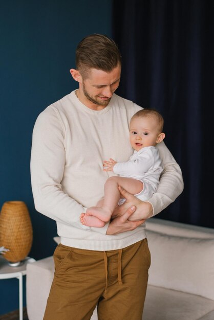 Un jeune père tient doucement un bébé mignon dans ses bras Portrait d'un père et d'un petit enfant d'un fils