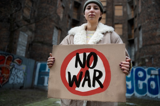 Jeune personne tenant une pancarte de protestation contre la guerre