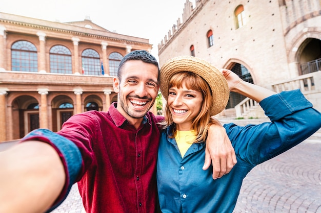 Jeune petit ami et petite amie amoureux s'amusant à prendre un selfie lors d'une visite de la vieille ville