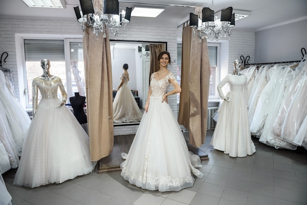 Jeune et petite mariée en robe de mariée dans le salon