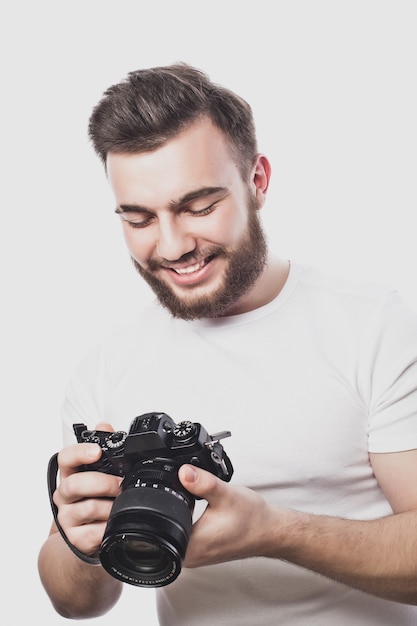 Jeune photographe barbu prenant des photos avec un appareil photo numérique