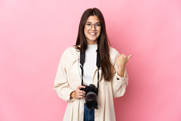 Jeune photographe brésilien fille isolée pointant vers le côté pour présenter un produit