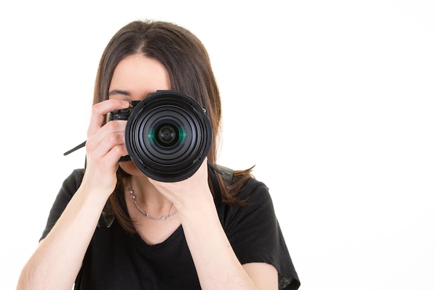 Jeune photographe brune prendre une photo femme isolée sur fond blanc avec espace de copie