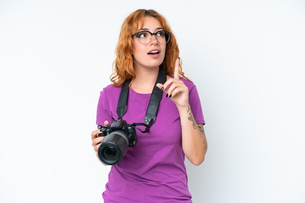 Photo jeune photographe caucasien femme isolée sur fond blanc pensant une idée pointant le doigt vers le haut