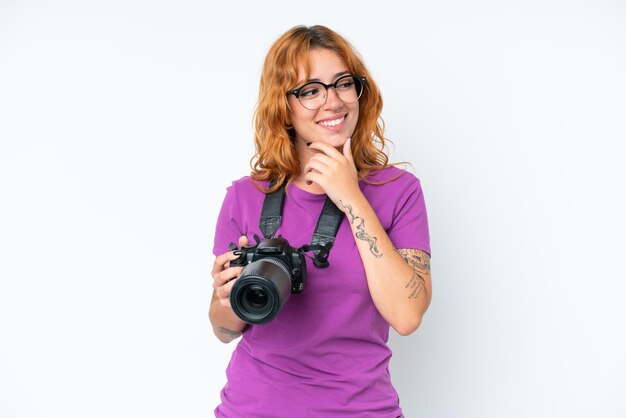 Photo jeune photographe caucasien femme isolée sur fond blanc regardant sur le côté et souriant
