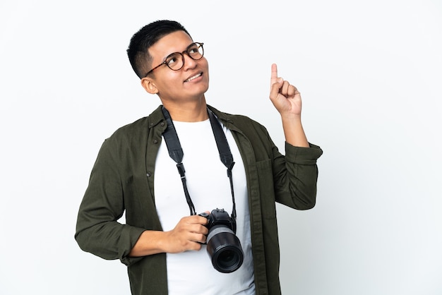 Jeune photographe équatorien isolé sur un mur blanc pointant vers le haut une excellente idée