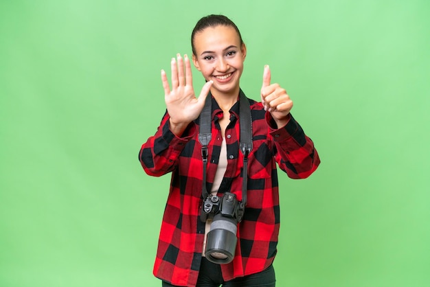 Jeune photographe femme arabe sur fond isolé comptant six avec les doigts