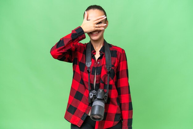 Jeune photographe femme arabe sur fond isolé couvrant les yeux par les mains et souriant