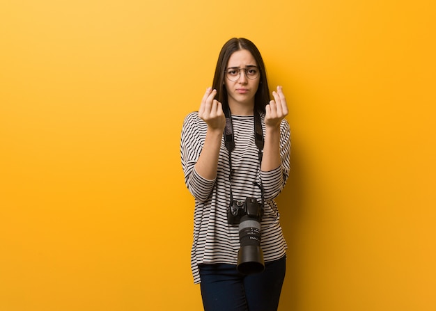 Jeune photographe femme faisant un geste de besoin