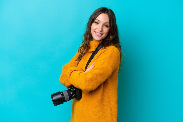 Jeune photographe femme isolée sur fond bleu avec les bras croisés et impatient