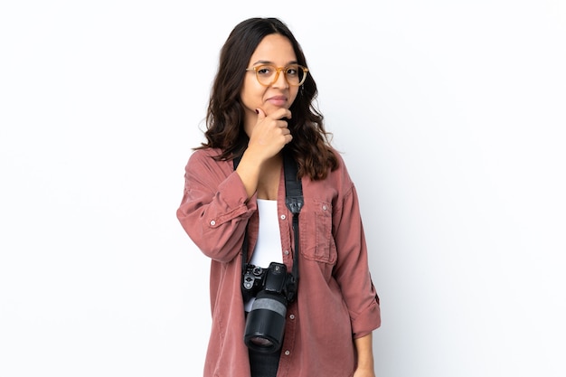 Jeune photographe femme sur mur blanc isolé pensant