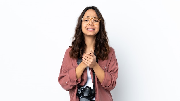 Jeune photographe femme sur mur blanc en riant