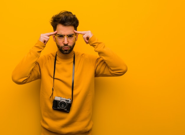 Jeune photographe homme faisant un geste de concentration