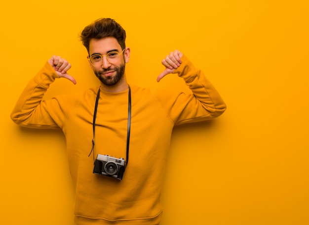 Jeune photographe homme pointant les doigts, exemple à suivre