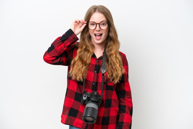 Jeune photographe jolie femme isolée sur fond blanc avec des lunettes et surpris