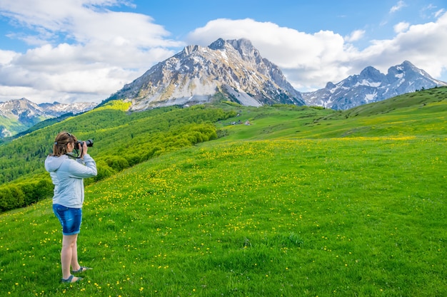 La jeune photographe photographie le sommet de la montagne Komovi. Monténégro.