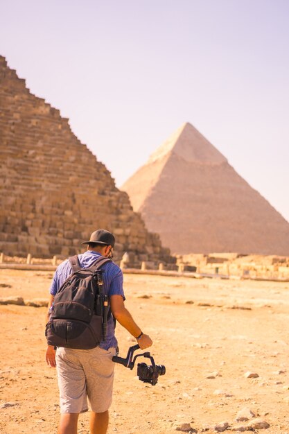 Un jeune photographe à la pyramide de Khéops la plus grande pyramide. Les pyramides de Gizeh le plus ancien monument funéraire du monde. Dans la ville du Caire, Egypte