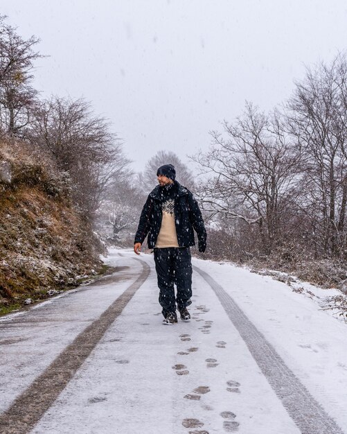 Un jeune photographe sur la route enneigée du Mont Aizkorri à Gipuzkoa